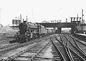 Ex-LMS 8F 2-8-0 No 48474 trundles through Nuneaton station at the head of a down train of empty coal wagons in 1952