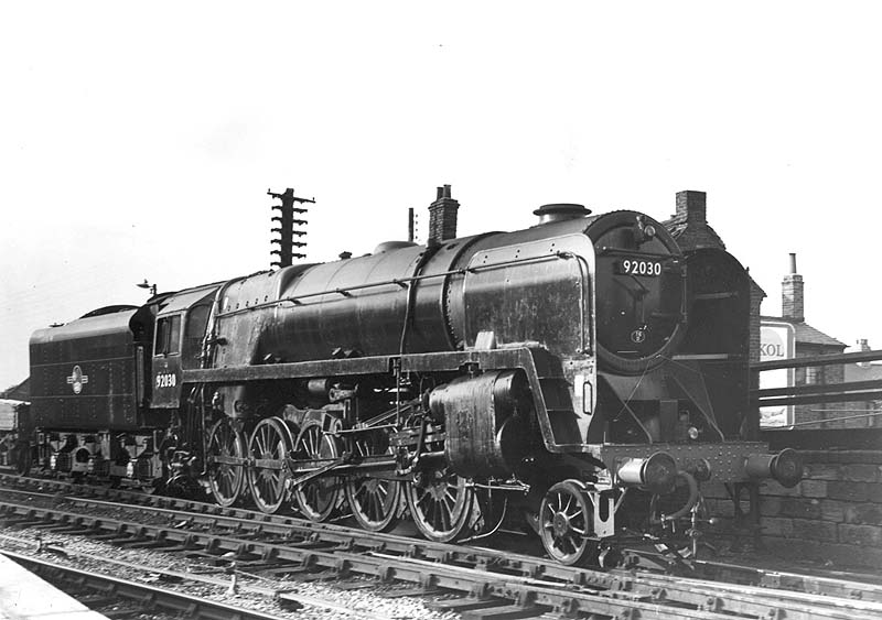 British Railways Standard class 9F No 92030 is seen at the head of a goods train leaving the up marshalling yard