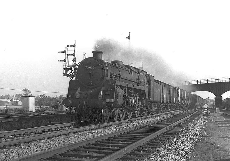 British Railways 4-6-0 Standard class 5MT No 73033 is seen passing under the Midland line to Leicester on a down Class C goods service
