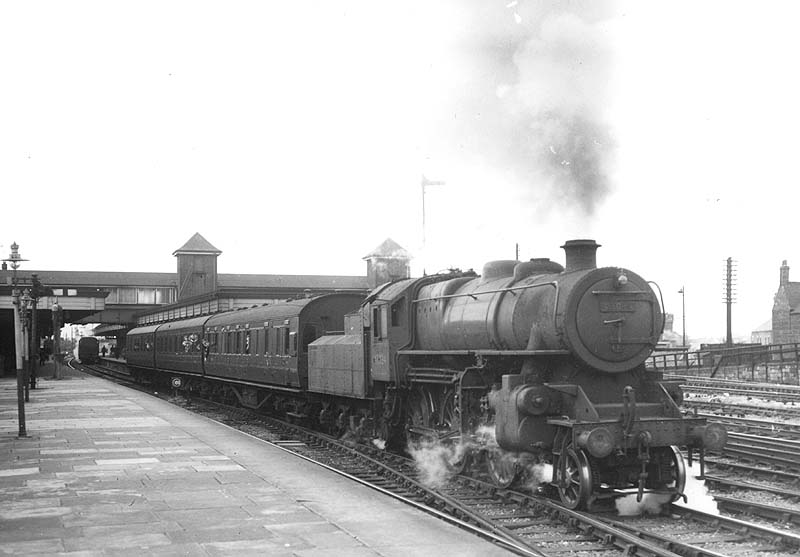 Ex-LMS 4MT 2-6-0 No 43034 is seen leaving platform two on a three-coach local stopping packed with school boys on train to Leicester
