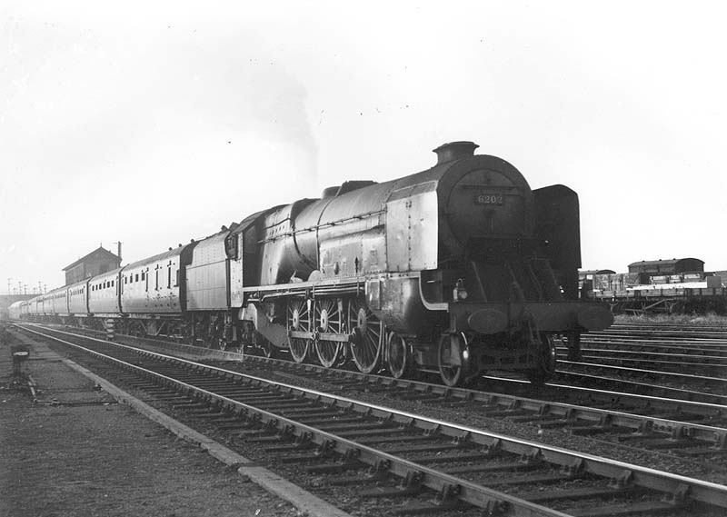 LMS 4-6-0 Stanier Pacific No 6202, unofficially known as 'Turbomotive', is seen at the head of an up express passing Nuneaton No 1 Signal Box