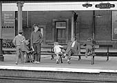 Two families wait patiently on platform three for their train home on Thursday 13th August 1964