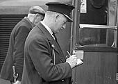 The train guard writes down the time that D319 is officially coupled up and ready to depart for Euston