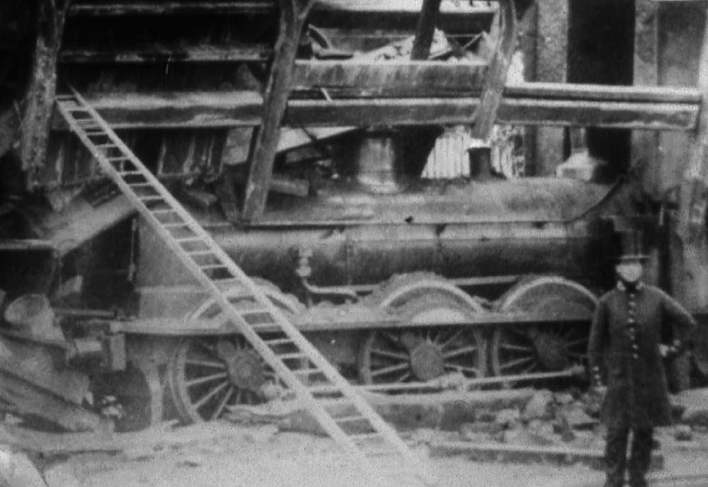 Close up showing collapsed bridge with the tender standing vertically above the footplate