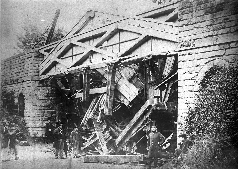 Oblique view of the collapsed bridge as it  is being inspected by the local coroner and other locals