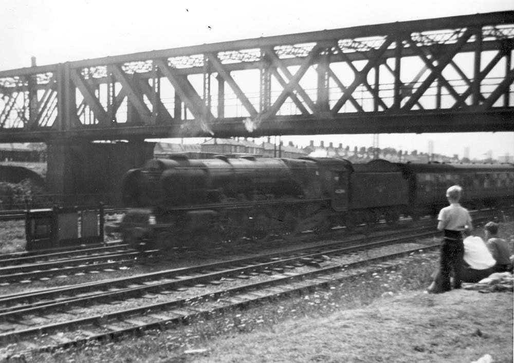 Ex-LMS 4-6-2 7P Coronation Class No 46225 'Duchess of Gloucester' passes beneath the Great Central 'Bird Cage' bridge during the summer of 1960