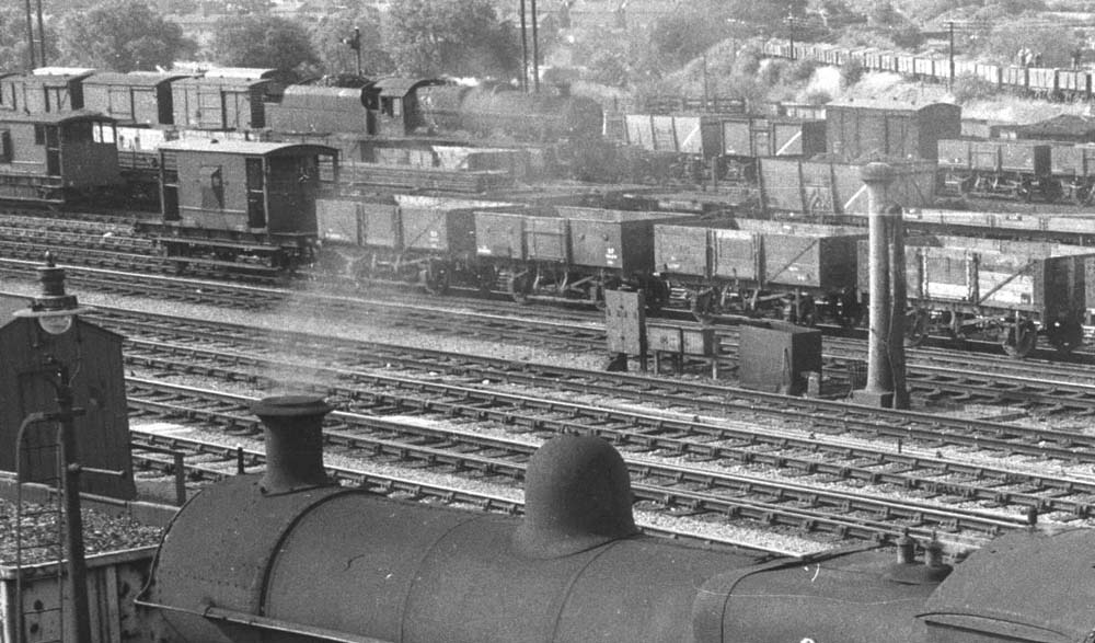 Close up showing an ex-LMS 4-6-0 5XP locomotive arriving in the up marshalling yard sidings with a train of box vans