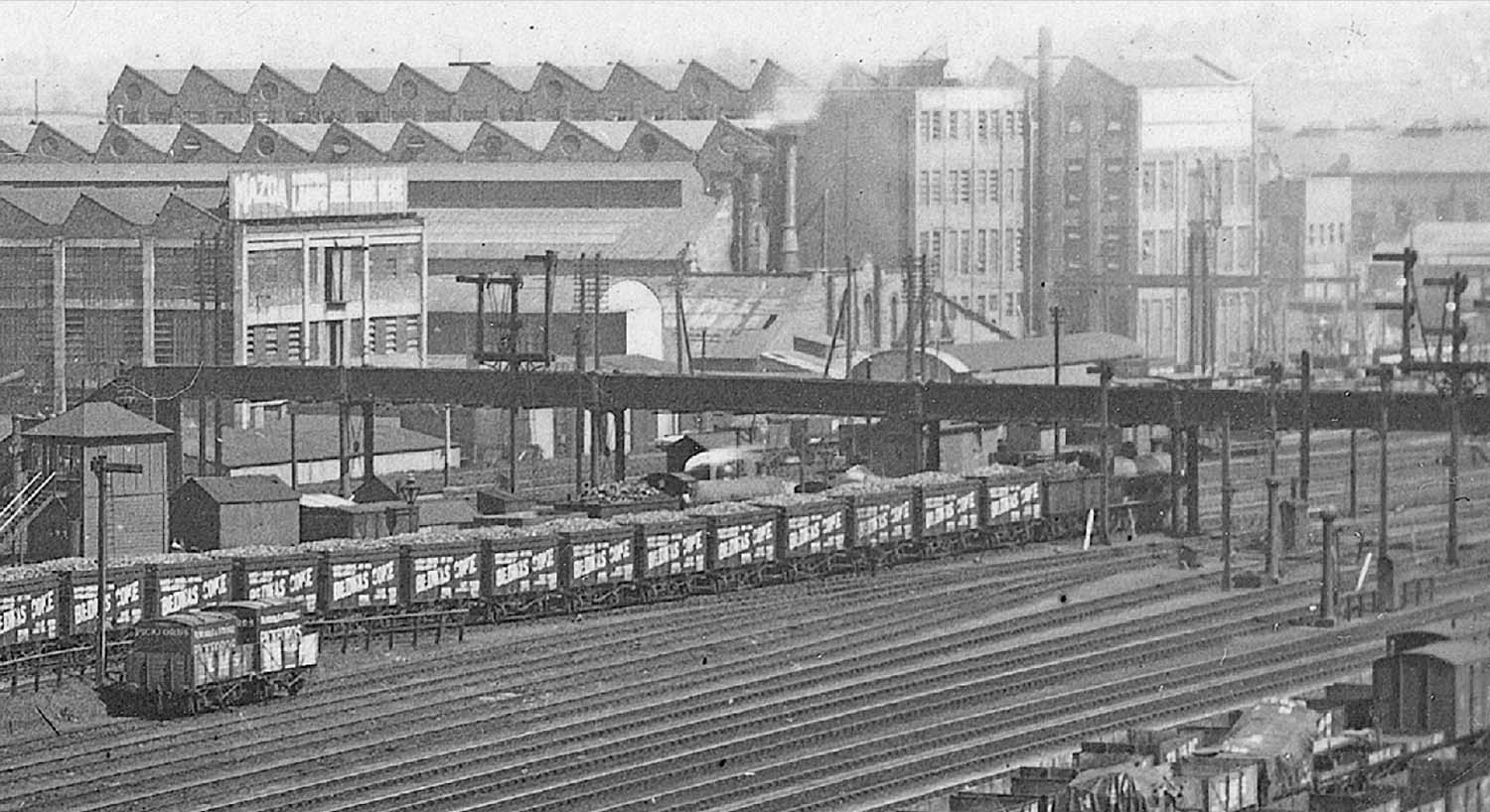 Close up showing the ex-LNWR 0-8-0 'Super D' goods locomotive at the head of a train of Bedwas Coke wagons with the Midland Railway Signal Box on the left