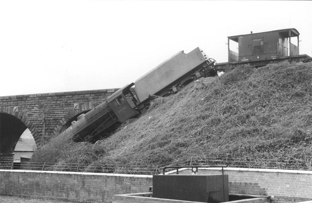 Ex-LMS 8F 2-8-0 No 48263 is seen lying down the embankment after running through the buffers on 16th December 1962