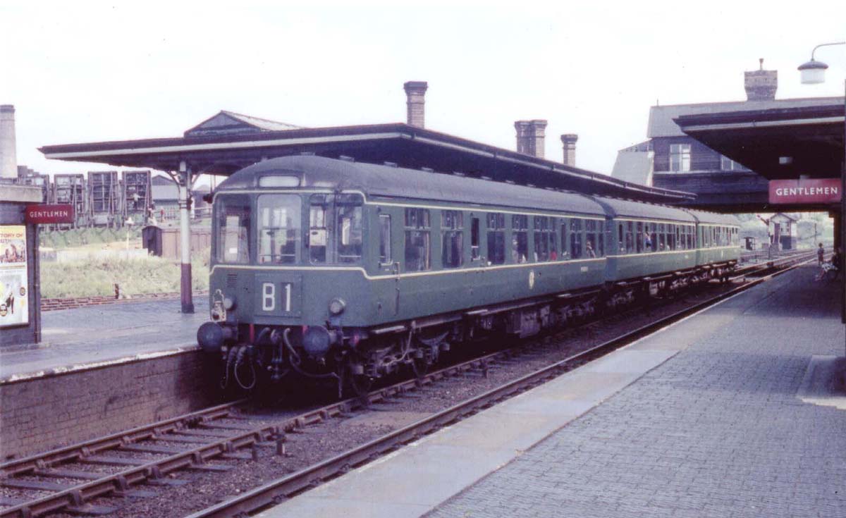 A three-car Derby lightweight Diesel Multiple Unit stands at Stechford station with the 13:38 pm Birmingham New Street to Rugby service
