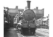 Close up of an unidentified ex-LNWR 2F 0-6-0 'Cauliflower' standing in front of and alongside of other locomotives of the same class