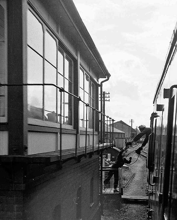 The fireman exchanges tokens with the signalman on a Redditch to Ashchurch train in June 1962