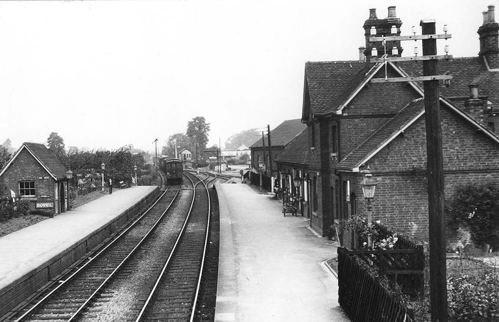 An ex-LNWR guards van protects the end of a goods train as it runs north past the junction with the GWR branch to Bearley