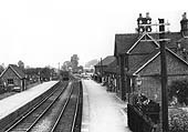 An ex-LNWR guards van protects the end of a goods train as it runs north past the junction with the GWR branch to Bearley
