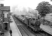 Ex-LMS 4F 0-6-0 No 44226 is seen at the head of a Class D freight passes through the station on 16th August 1963