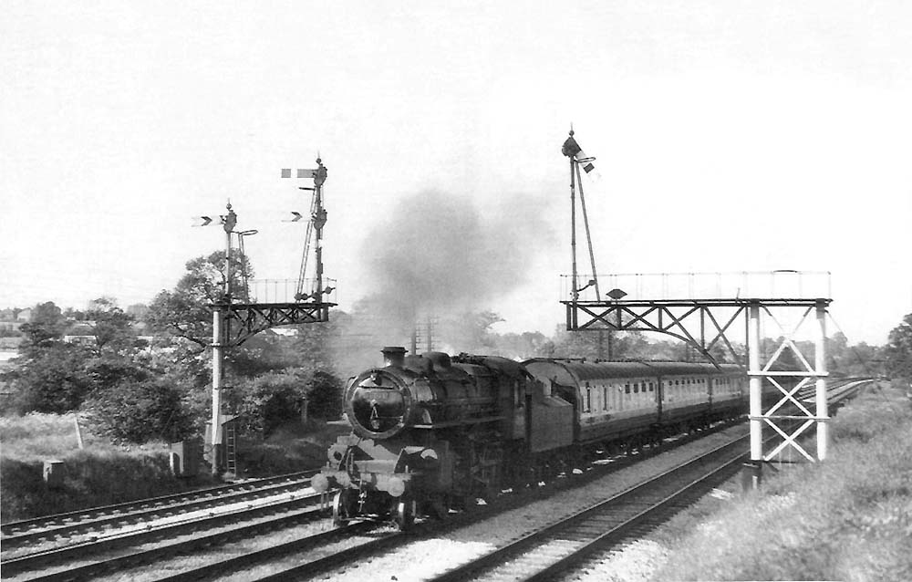 British Railways built 4MT 2-6-0 No 43036 is seen at the head of a down ordinary passenger service on 18th June 1953