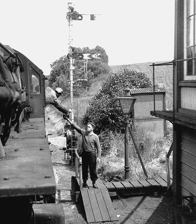 The driver of Ivatt Mogul No 43049 is about to collect the tablet by thrusting his hand through the centre of the hoop