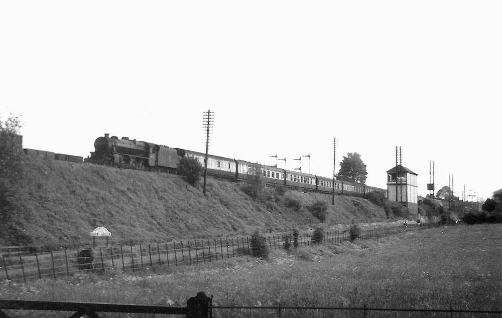 Ex-LMS 4-6-0 Black 5 No 44945 having passed Barnt Green station is seen on a Bristol to New Street express service on 8th June 1954