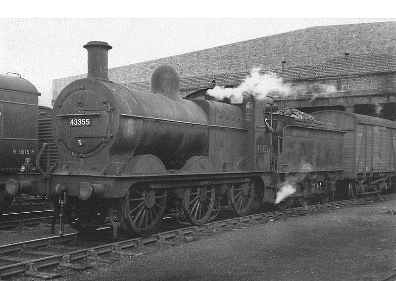 Ex-Midland Railway 0-6-0 3F No 43355 is seen on shunting duties as it marshals vans in the yard to the front of the rebuilt warehouse