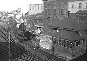 View of Central Goods Depot's signal box as ex-MR 0-6-0 3F No 43675 leaves the yard at the head of a freight train