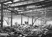 Firemen are seen dampening down the smouldering remains of the warehouse on the 26th October 1940