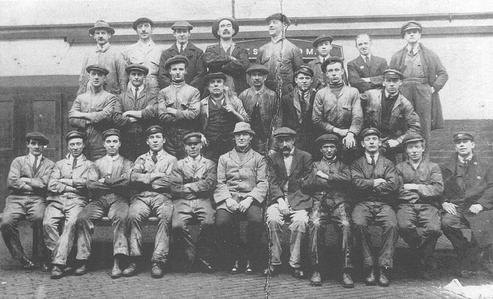 A 1920s photograph showing some members of staff Bournville Shed seated either side of the shed foreman
