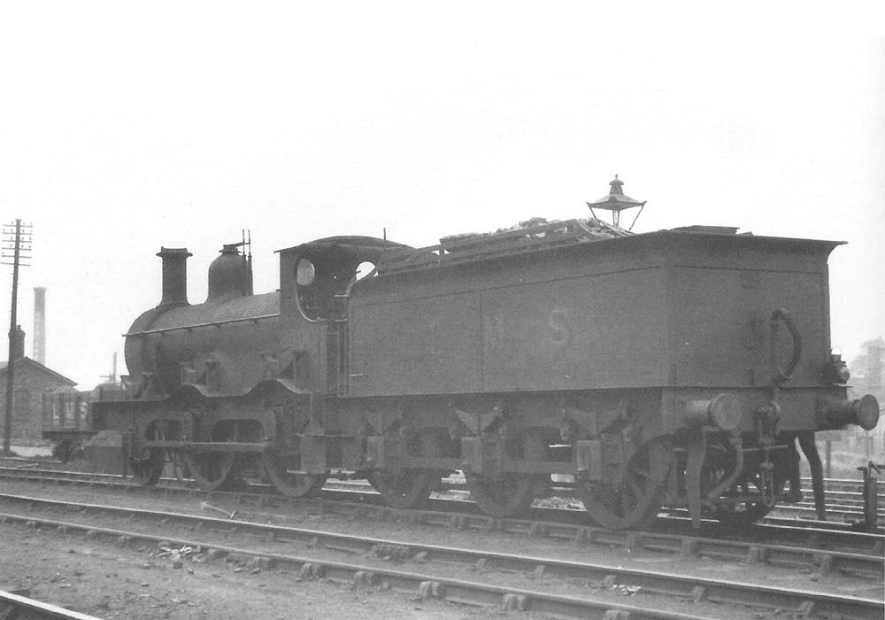 An ex-MR double framed 2-4-0, LMS No 20002, is seen on the ash pit road on a June evening in 1935