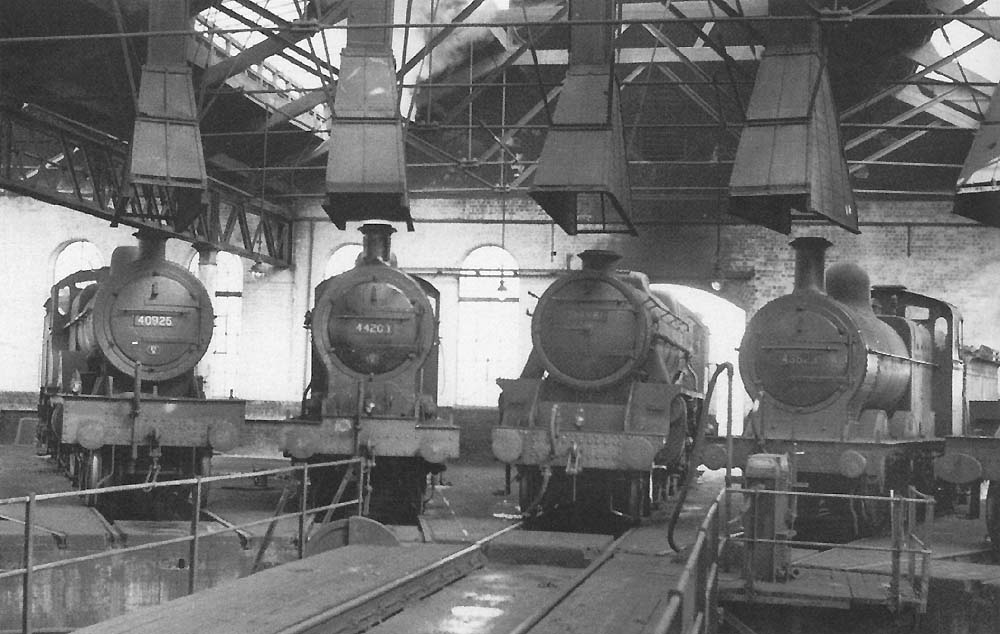 Different types of engine seen standing in adjacent bays in the roundhouse in the 1950s