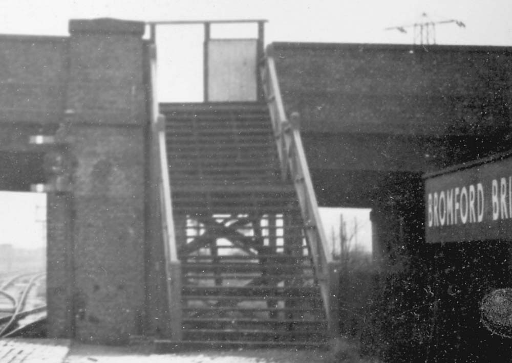 Close up showing on the left the signals controlling traffic reversing in to the sidings and the steps up to Bromford Lane bridge