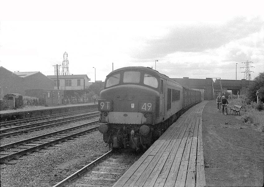 An unidentified Sulzer Type 4 locomotive passes Bromford Bridge's up platform with a short train of vans