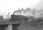 An unidentified former Franco-Crosti boilered 8F 2-10-0 locomotive passes over the River Tame with a Class F express freight service