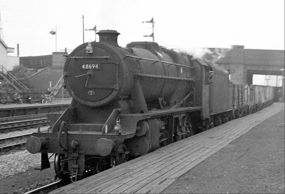 Ex-LMS 5MT 4-6-0 No 48694 passes through the station on an up Type 7 express freight service