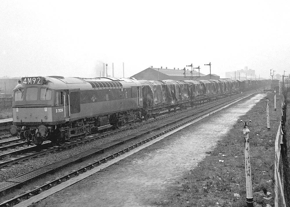 View of D7624 at the head of a freight train passing through Bromford Bridge station after it closed to normal passenger services