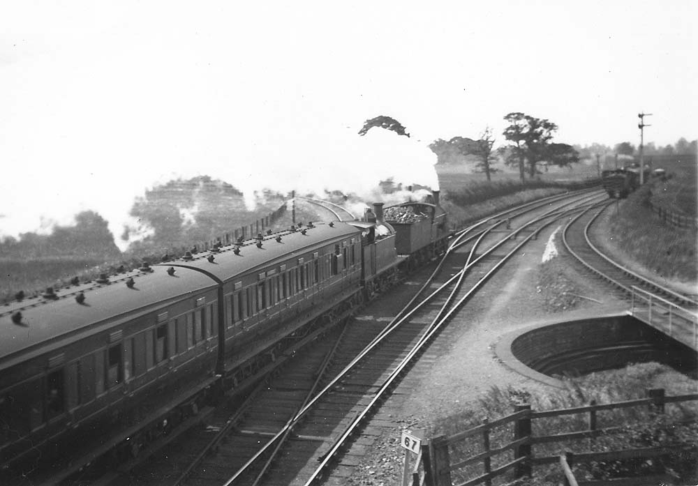 A MR 0-6-0 2F locomotive pilots a Johnson 0-4-4T locomotive departs with a train for Evesham circa 1923