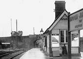 Close up showing the Redditch end of the station building with a weighing machine standing under the window