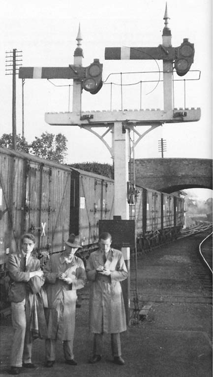 A London Midland Scottish Railway Banana train stands in Broom Junction as a party of enthusiasts look on in 1934