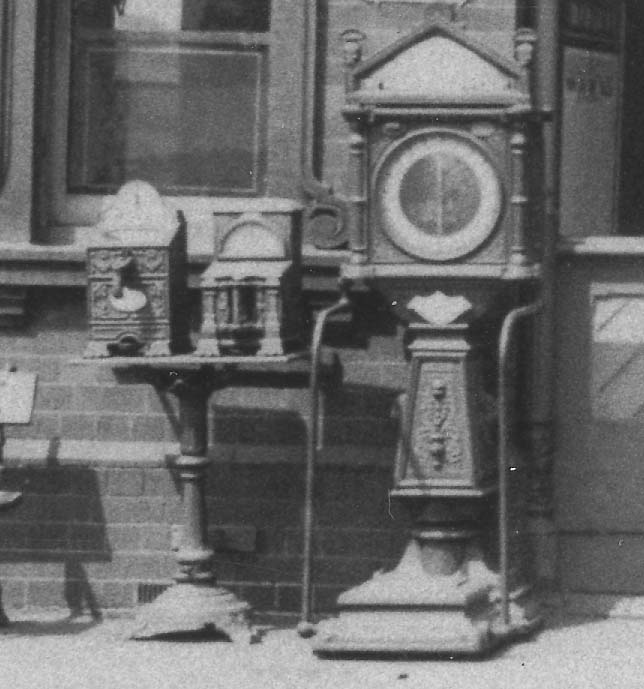 Close up showing the two cast-iron mechanical vending machines and the luggage weighing machine