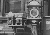 Close up showing the two cast-iron mechanical vending machines and the luggage weighing machine
