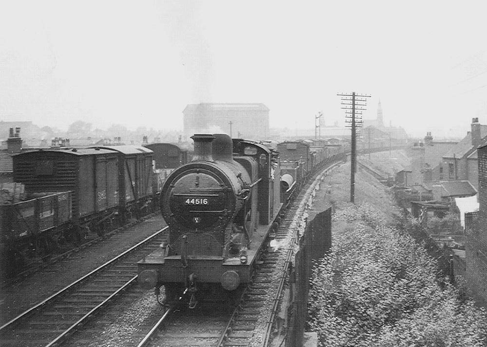 Ex-LMS 0-6-0 4F No 44516 is seen at the head of a train combining two sets of locomotives and wagons