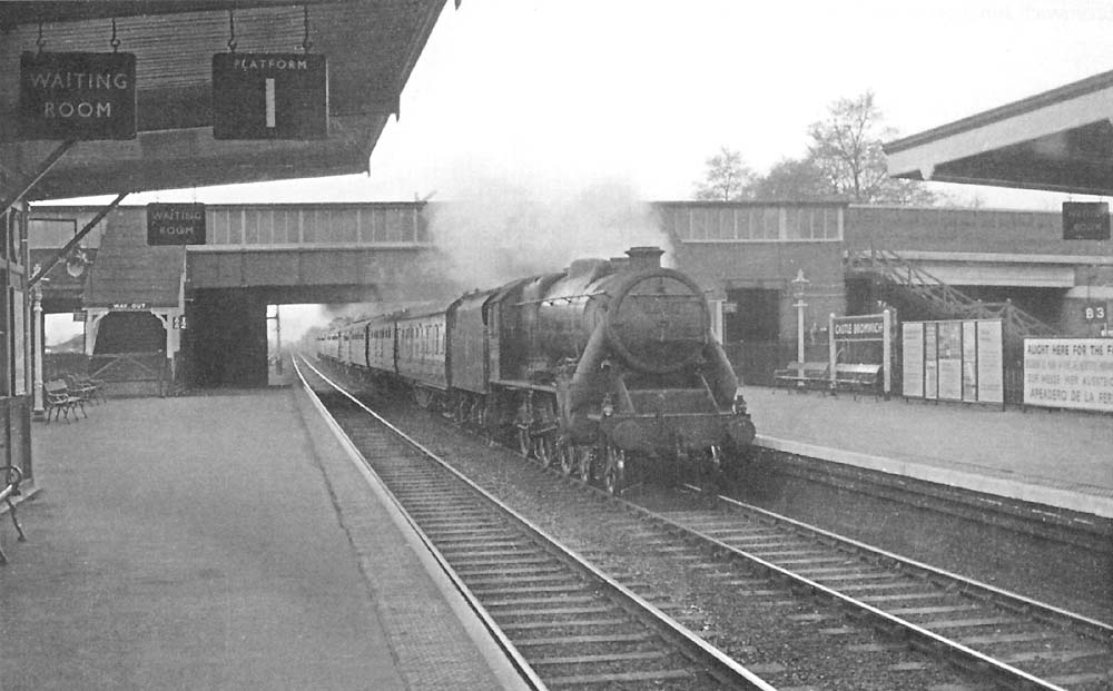 An unidentified British Railways built 5MT 4-6-0 'Black Five' roars through the station on an up express service to Derby