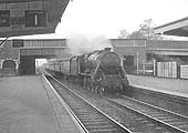 An unidentified ex-LMS 5MT 4-6-0 'Black Five' roars through the station on an up express service to Derby