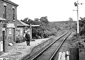 Close up showing the stationmaster posed on Coleshill station platform which has been raised to the height of the window sill