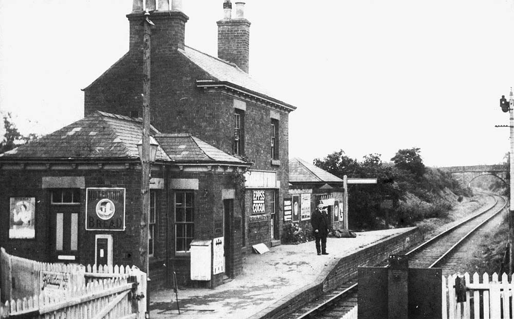 Looking towards Hampton with the short single platform station on the left and the level crossing gates in the foreground
