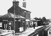 Looking towards Hampton with the short single platform station on the left and the level crossing gates in the foreground