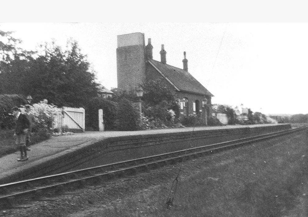 An oblique view of Coughton station looking towards Studley with the station covered with flowers and bushes on 4th May 1930
