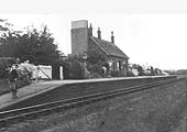 An oblique view of Coughton station looking towards Studley with the station covered with flowers and bushes on 4th May 1930