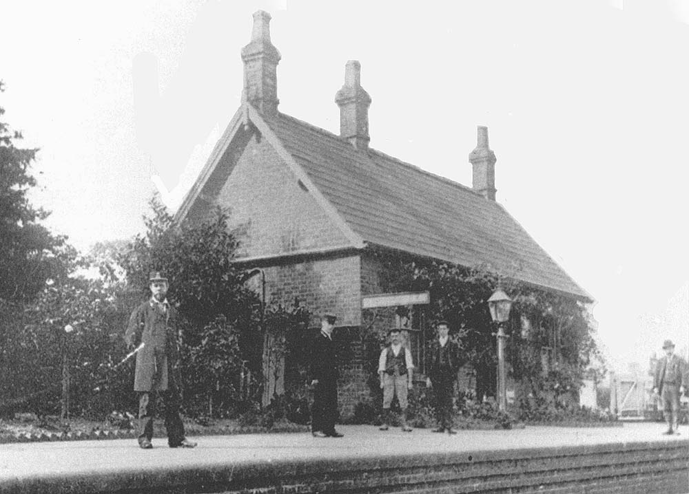 View of Coughton station from the opposite side with Station Master and porter posed with other passengers