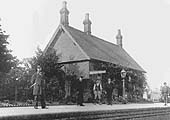 View of Coughton station from the opposite side with Station Master and porter posed with other passengers