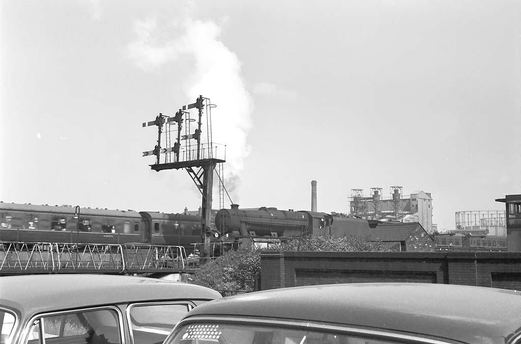 An unidentified ex-LMS 8F 2-8-0 locomotive reverses out of Saltley shed and over Duddeston Road during the early 1960s