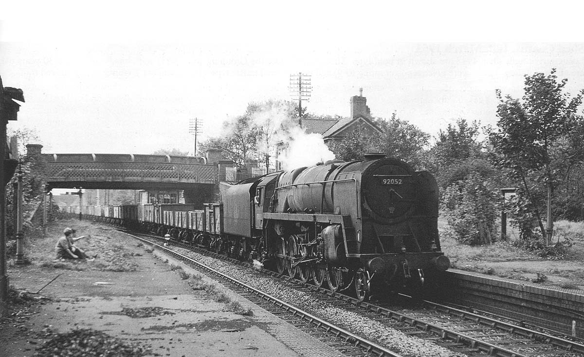 A BR Standard 2-10-0 9F trundles through the station